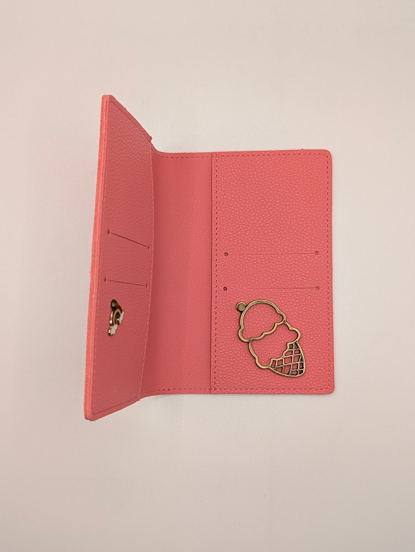 Pink wallet with ice cream charm on a beige background