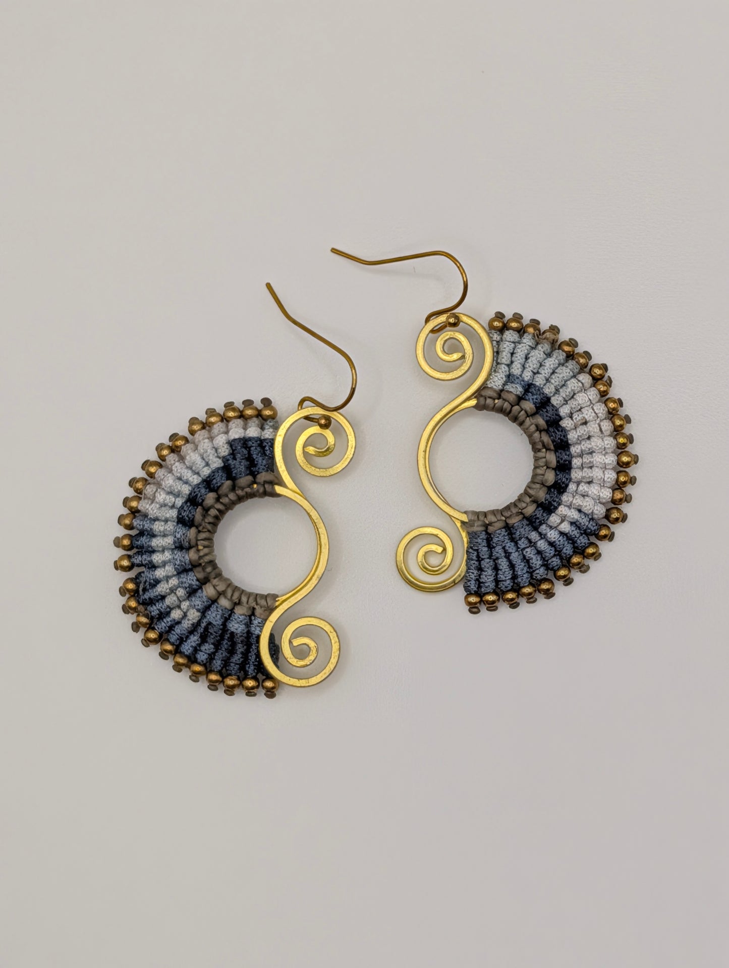 Pair of earrings with gold and multicolored design on a gray background