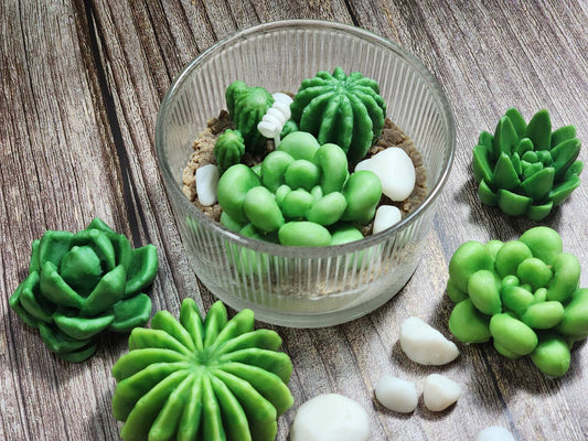 Green succulent-shaped cookies around a glass bowl on a wooden surface